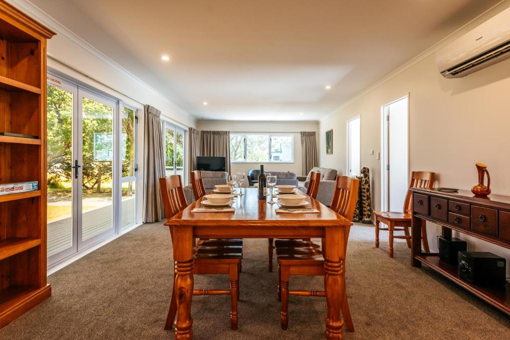 a dining room with a wooden table and chairs at Number Six - Oneroa Holiday Home in Oneroa