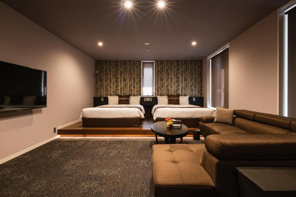 uma sala de estar com duas camas e um sofá em GRAND BASE Moji Nagomi em Kitakyushu