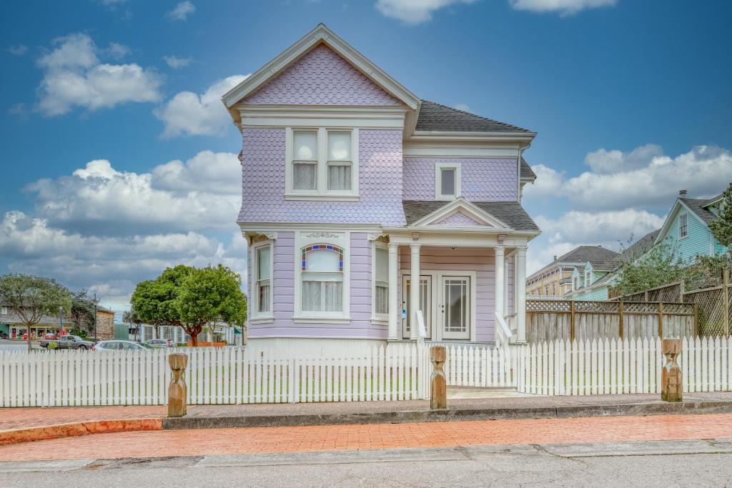 uma casa roxa com uma cerca branca em Lilac Victorian em Eureka