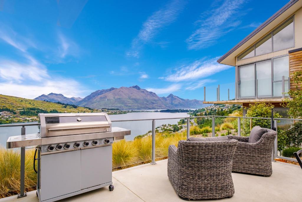a barbecue on a patio with a view of the water at Queenstown Lake Views - Downstairs Apartment in Queenstown