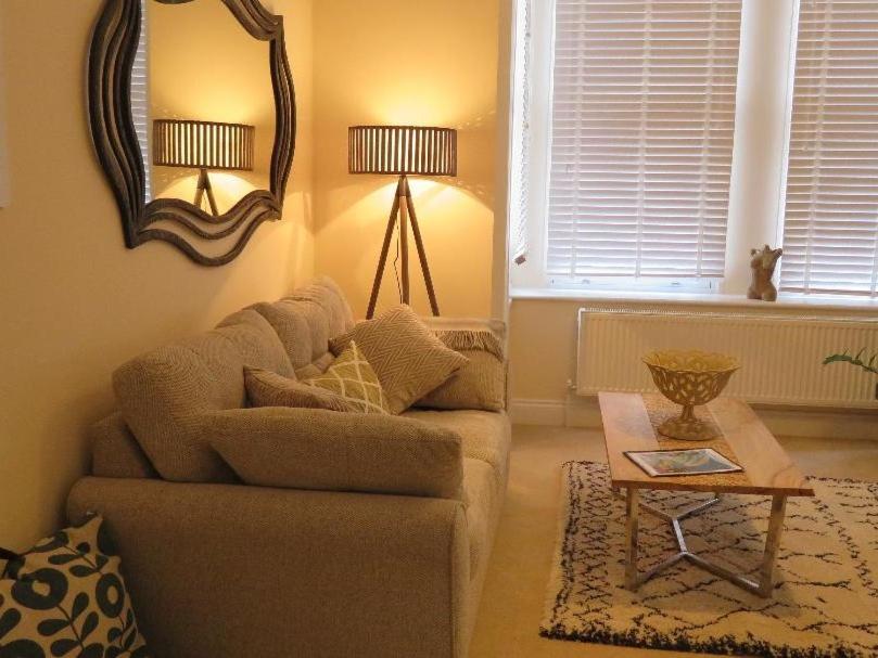 a living room with a couch and a table and a mirror at Stracey Road Apartment in Norwich