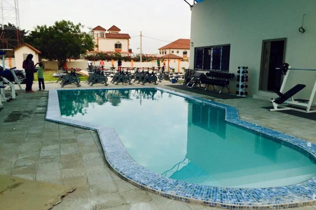 a large swimming pool with blue water in a yard at PARADISE ESTATE PEACEFUL QUITE COMFORTABLE SECURED GATED WIFI pOOL in Old Yundum