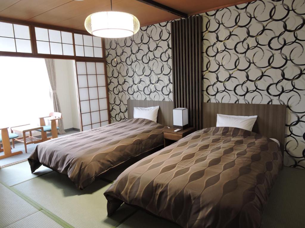 Postel nebo postele na pokoji v ubytování The Gran Resort Kinosaki