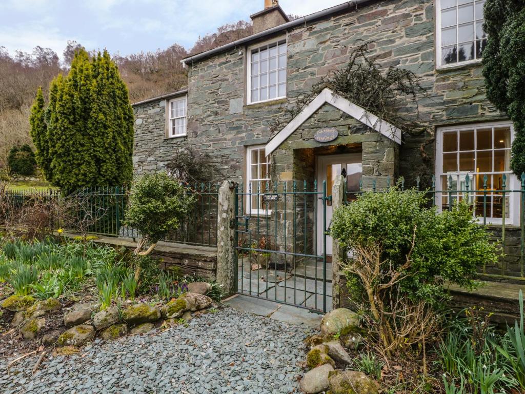 a stone house with a gate in front of it at Coombe Cottage in Borrowdale Valley