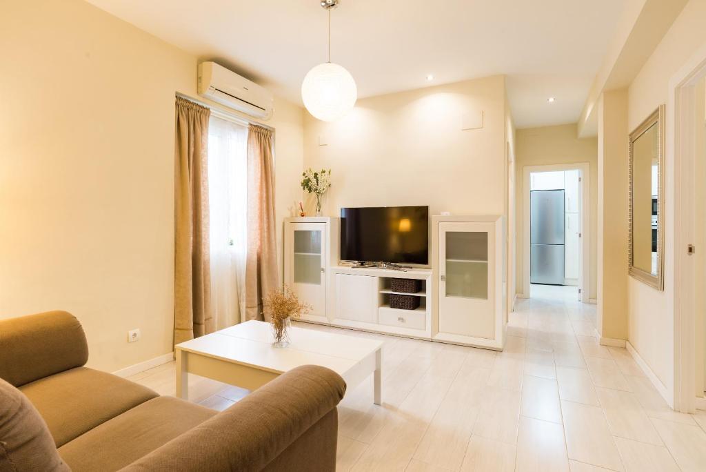 uma sala de estar com um sofá e uma televisão em Alferez I by ELE Apartments em Málaga