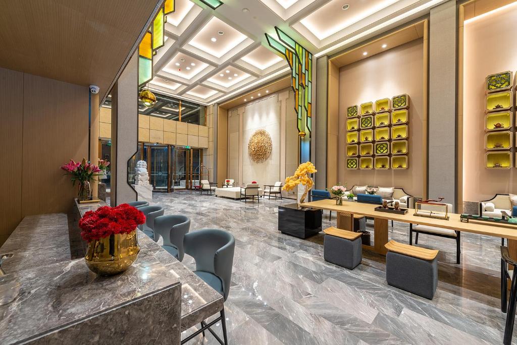 a lobby of a hotel with chairs and tables at Metropolo Jingjiang Hotels- JiangNan market ShuangLong in Guangzhou