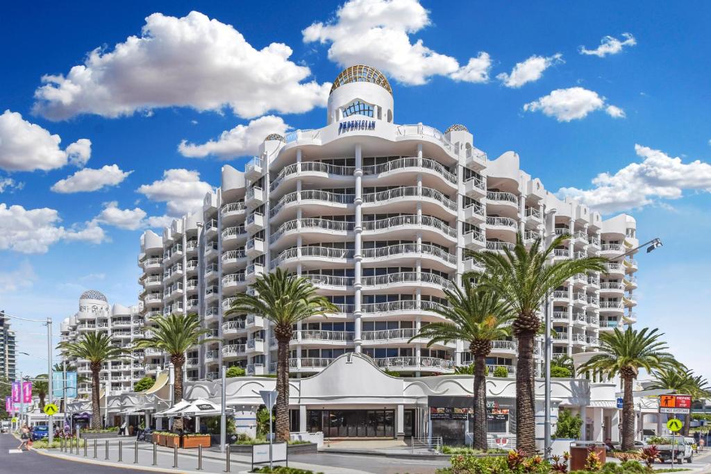 a large white building with palm trees in front of it at The Phoenician Resort in Gold Coast