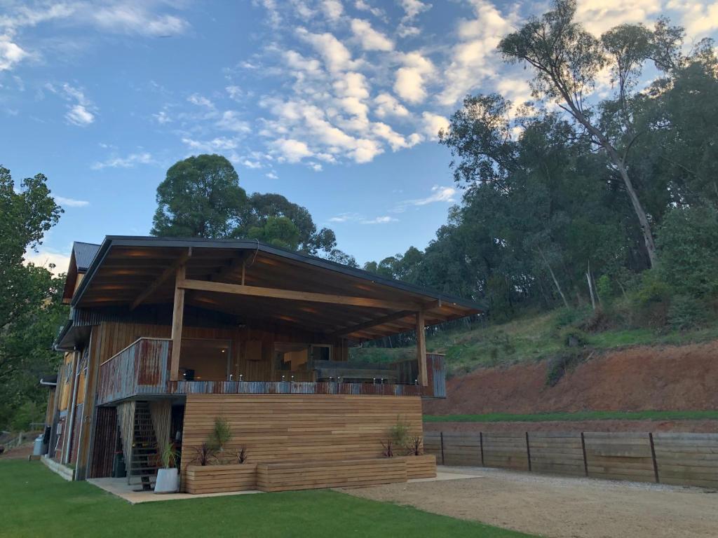 a house with a large deck on a hill at The Shed House in Mount Beauty