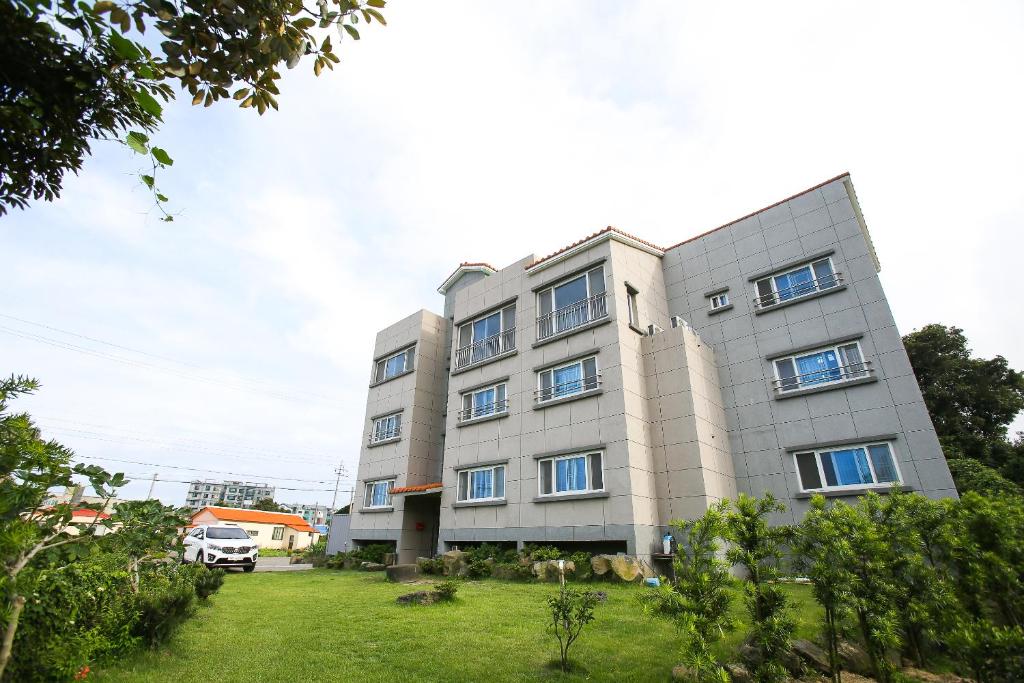 un gran edificio gris con un patio delante en Haeneoul, en Seogwipo