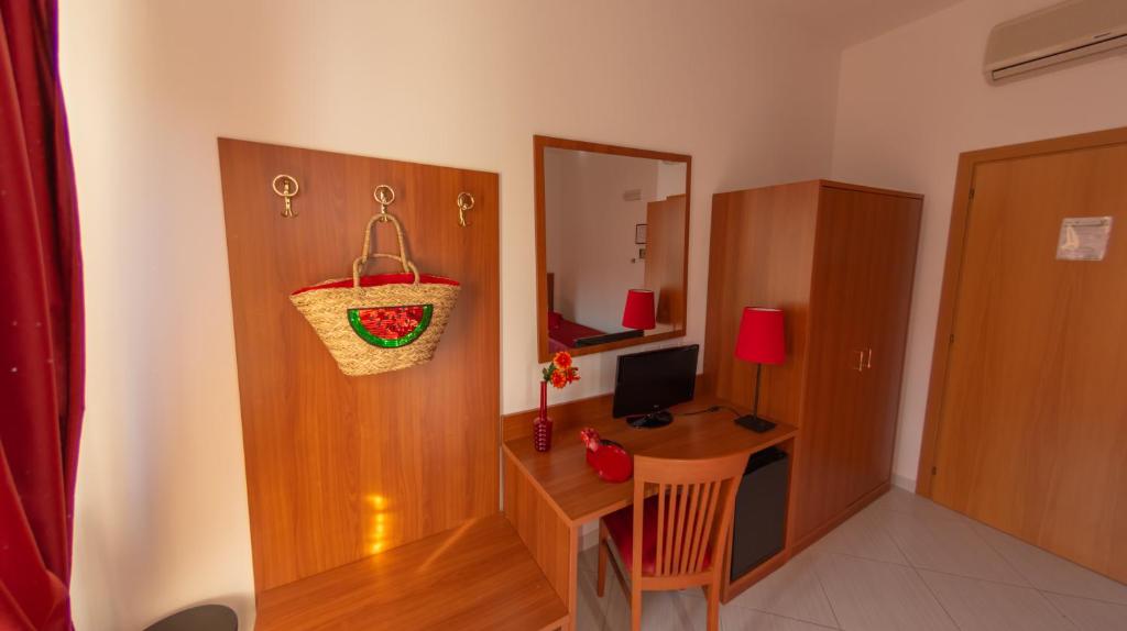 a room with a desk with a computer and a mirror at Hotel Solaria in Rodi Garganico