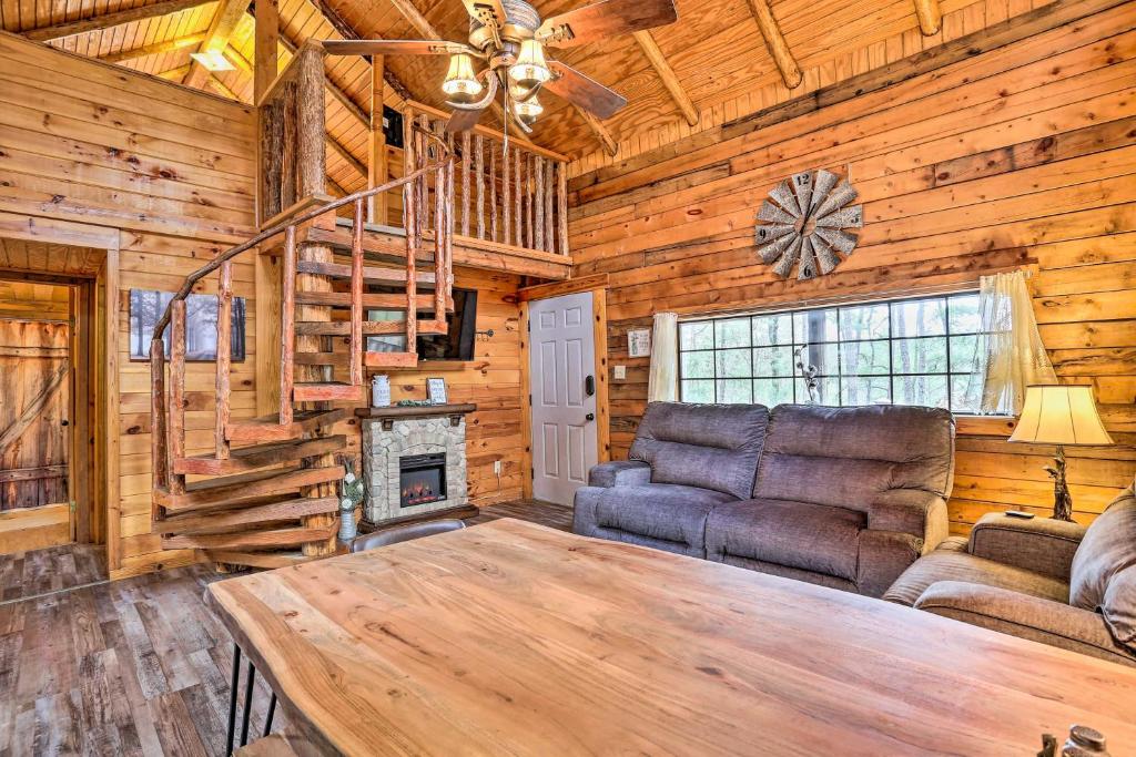 a living room with a couch and a fireplace at Authentic Log Cabin with Fire Pit, Pond, and More! in Broken Bow
