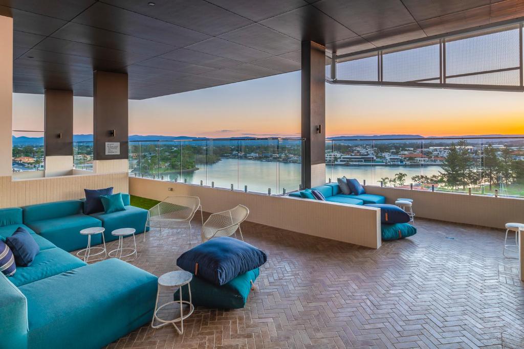 a lobby with blue couches and a view of the water at Peninsular Gold Coast in Gold Coast