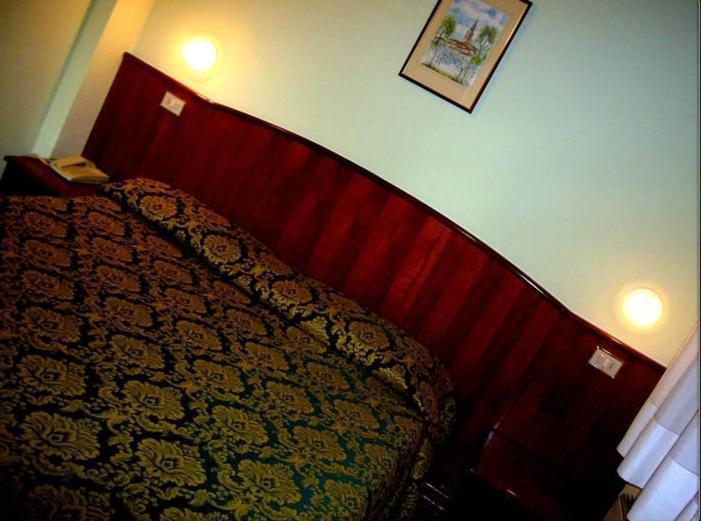 a bedroom with a bed with a red head board at Albergo La Meridiana in Portogruaro