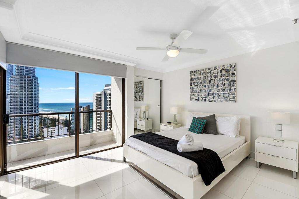a bedroom with a large bed and a large window at Surfers Century Oceanside Apartments in Gold Coast