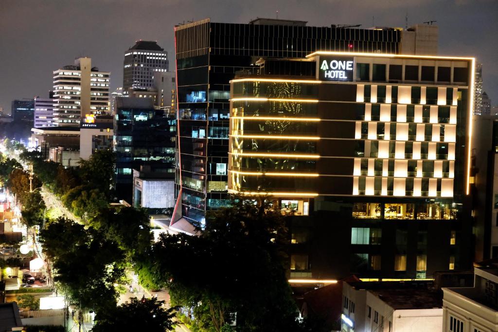 a lit up building in a city at night at AONE Hotel in Jakarta