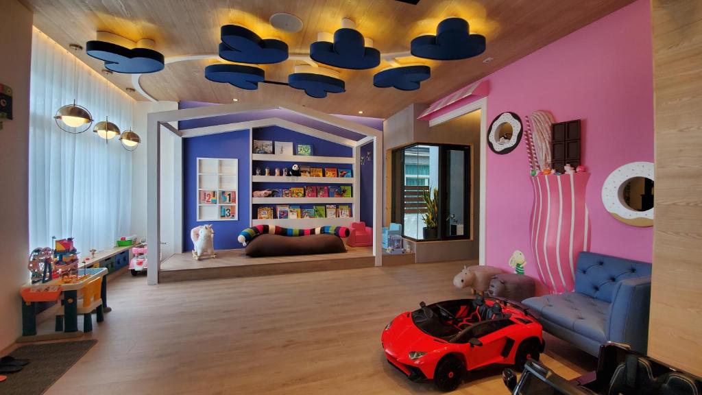 ein Kinderzimmer mit einem roten Spielzeugauto auf dem Boden in der Unterkunft Blocks Forest in Taitung