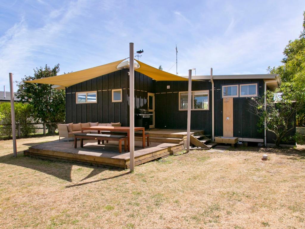 a small house with a picnic table in front of it at Taruna - Tauranga Taupo Holiday Home in Kuratau