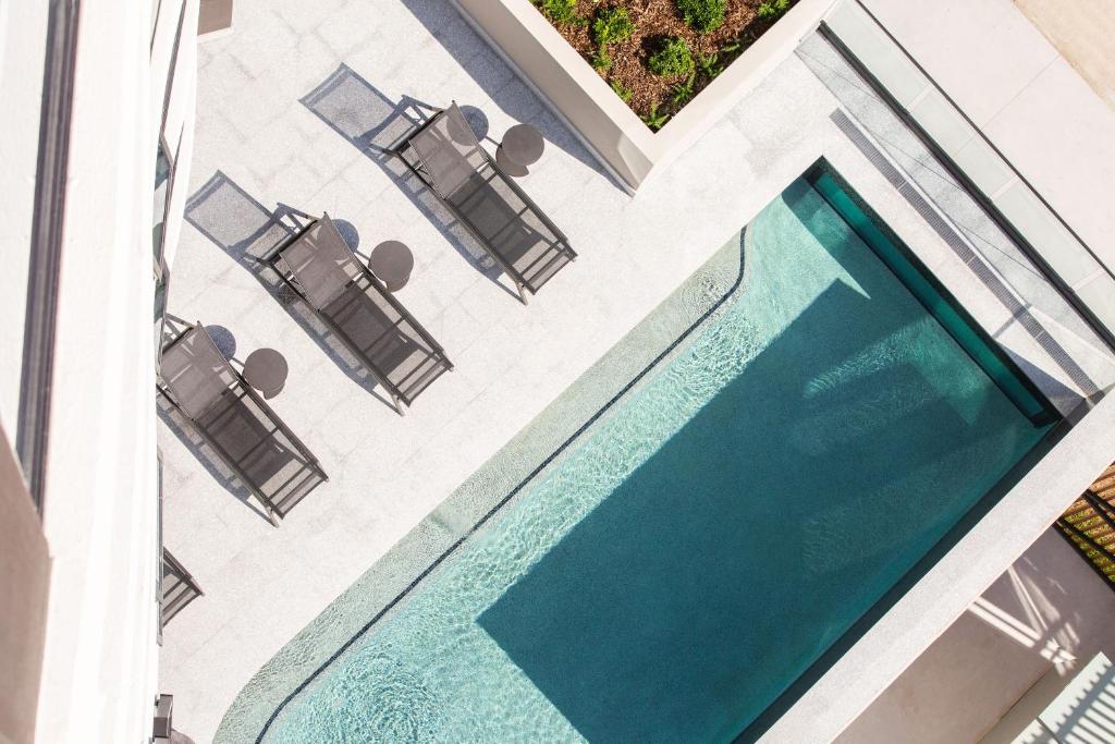 einen Pool mit Stühlen und einem Tisch in der Unterkunft Vue Broadbeach in Gold Coast