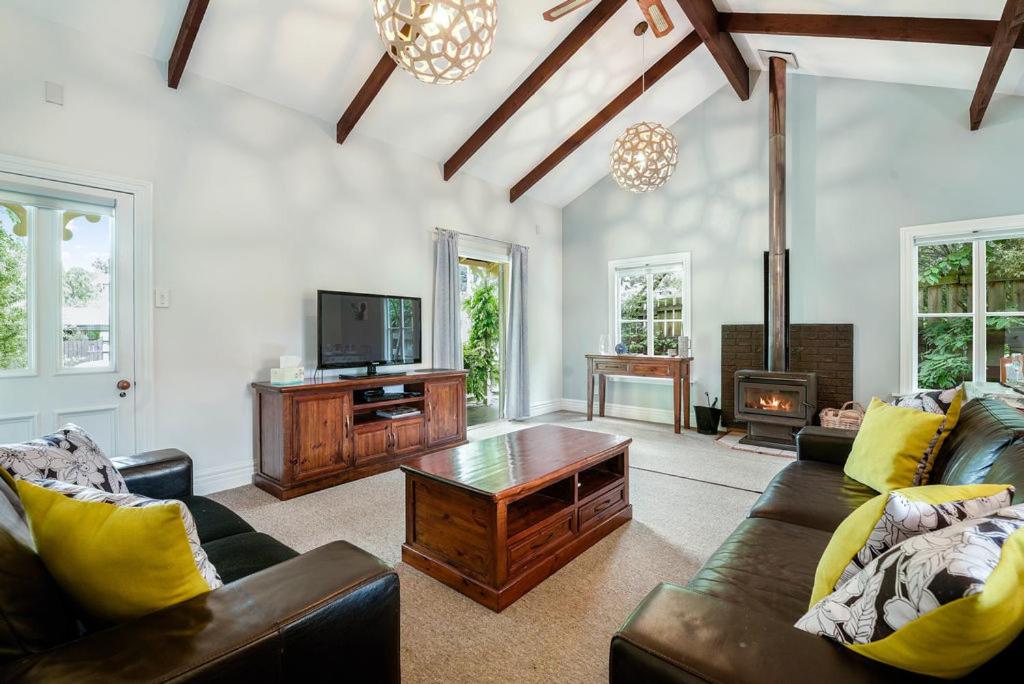 a living room with a couch and a table and a tv at Central Peach - Queenstown Holiday Home in Queenstown