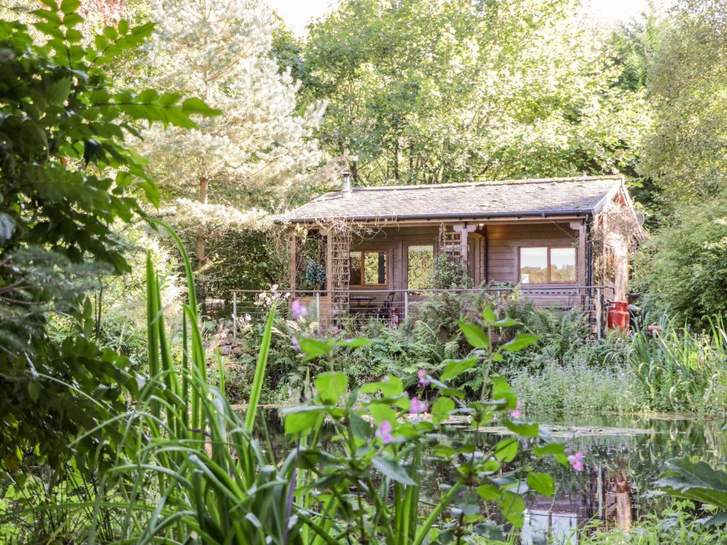 a small house in the middle of a garden at The Log Cabin in Kilmore