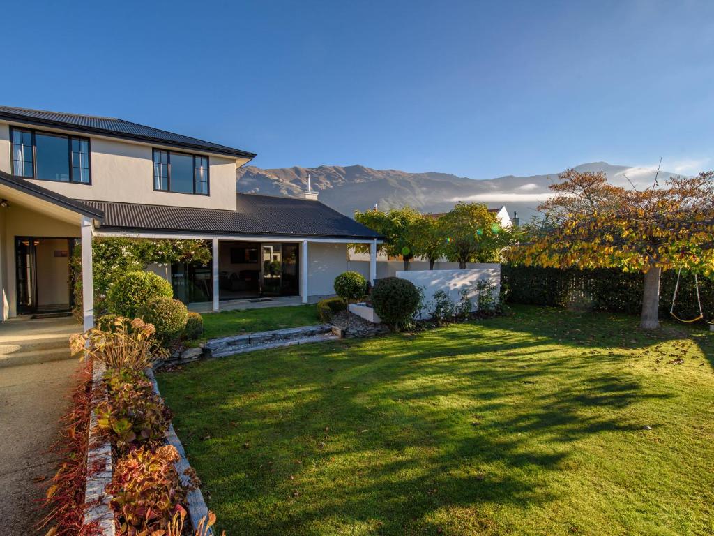 a house with a green yard in front of it at Willowridge Escape - Wanaka Holiday Home in Wanaka