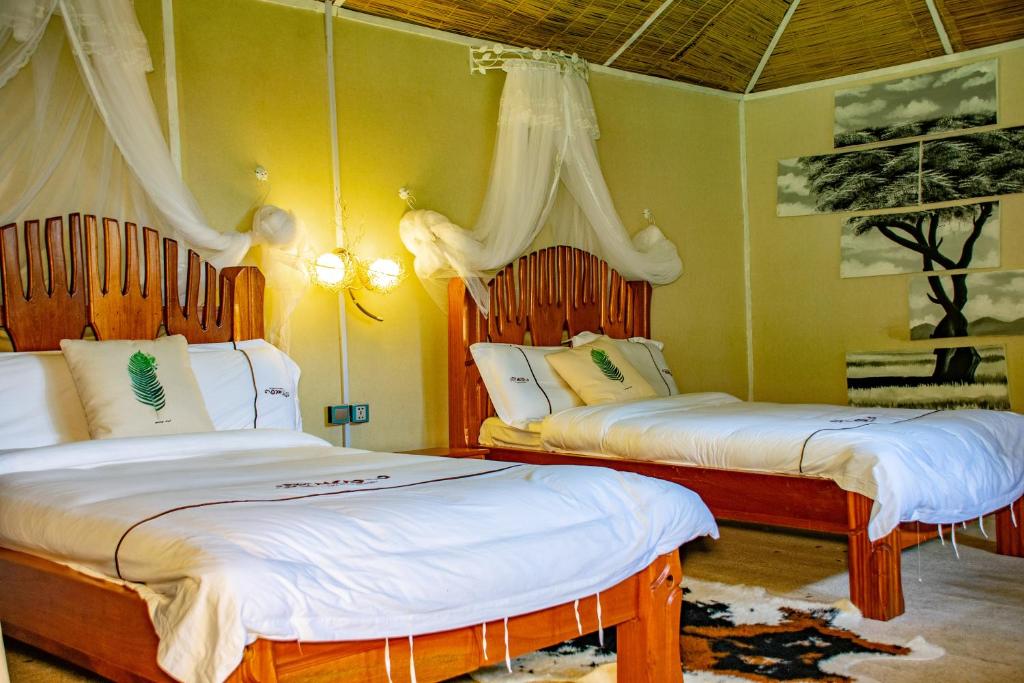 1 Schlafzimmer mit 2 Betten und weißer Bettwäsche in der Unterkunft Mara Chui Eco-Resort in Sekenani