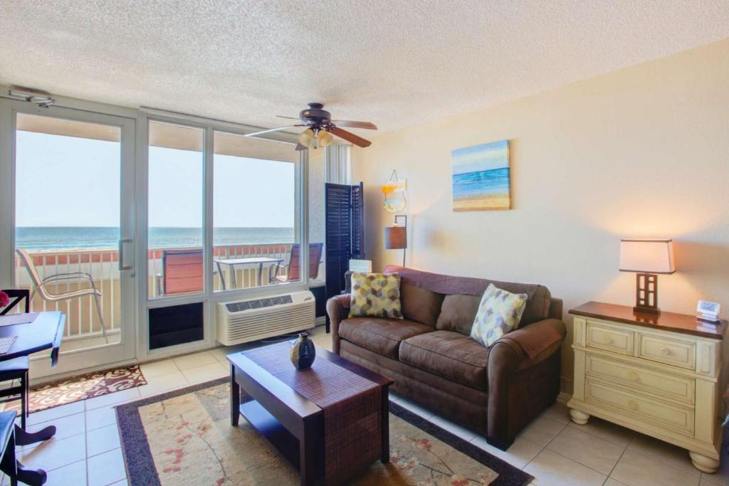 ein Wohnzimmer mit einem Sofa und Meerblick in der Unterkunft Pirates Cove Condo Unit #209 in Daytona Beach