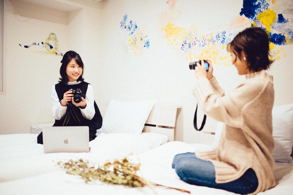 a woman taking a picture of a girl on a bed at torune in Sapporo