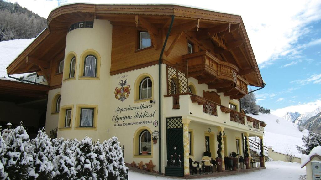 a large building with snow on the ground at Appartementhaus Olympia Schlössl in Neustift im Stubaital