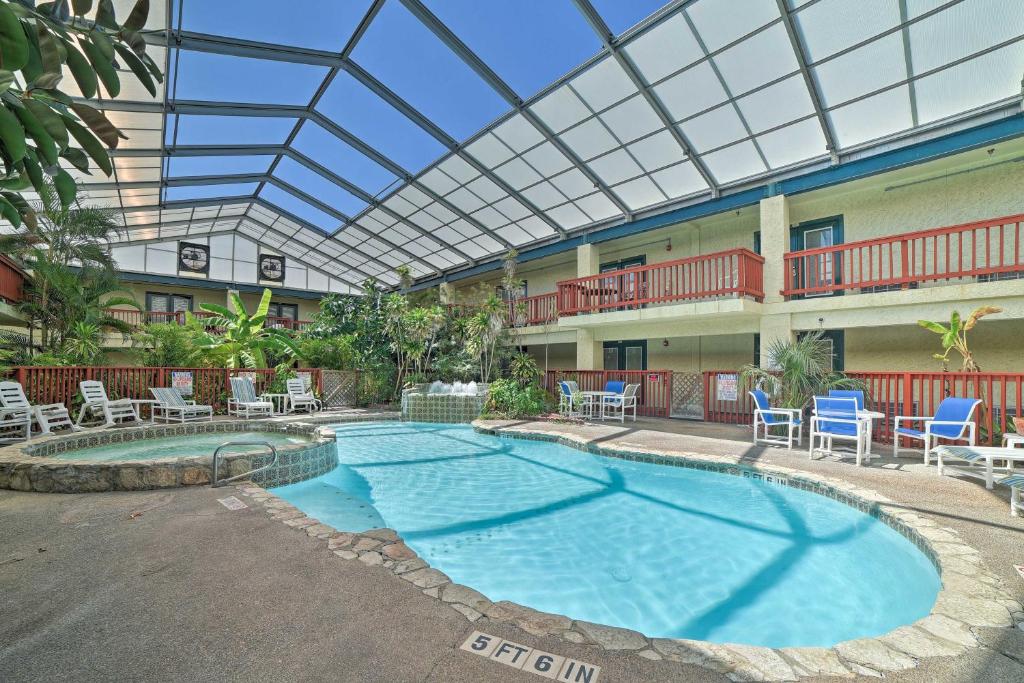 a large swimming pool with chairs and a glass ceiling at Coastal Studio with Amenities Walk to Padre Beach! in Corpus Christi