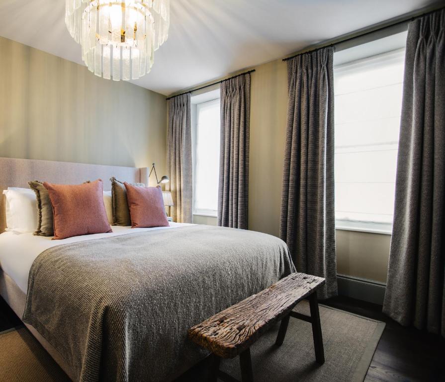 a bedroom with a large bed and a chandelier at Blonde Hedgehog in Alderney