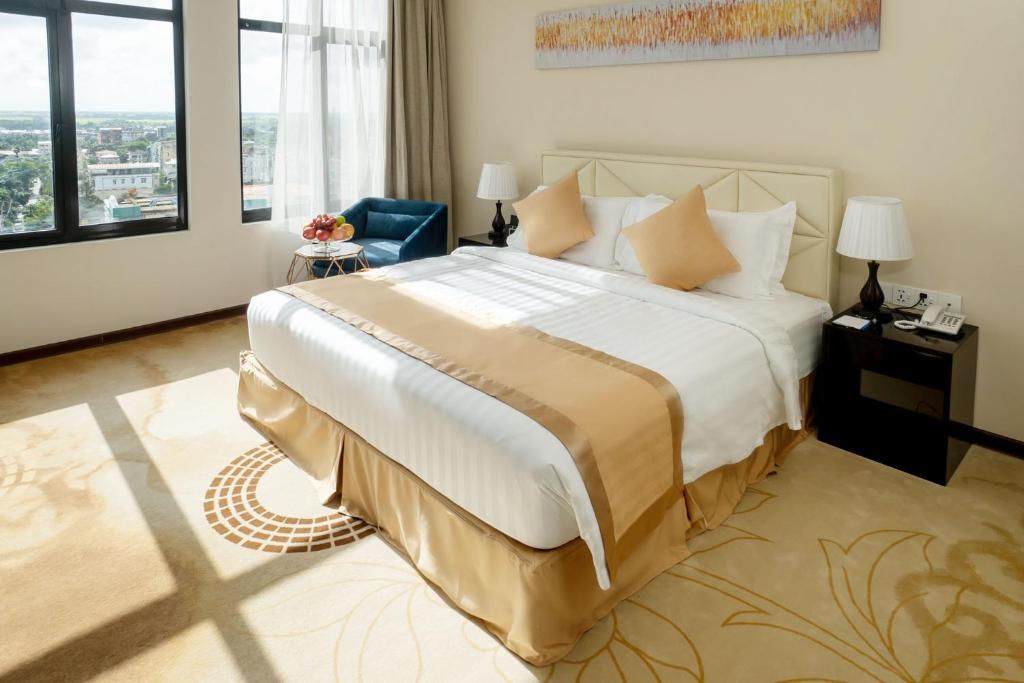 um quarto com uma cama grande e uma janela grande em Hotel Sanchaung em Yangon