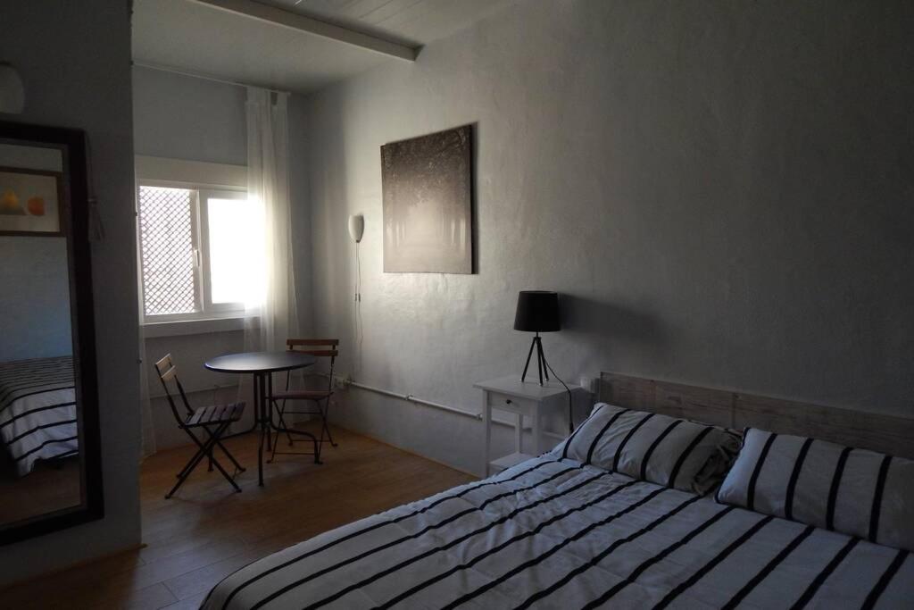 1 dormitorio con 1 cama, mesa y sillas en Cosy Flat for 2 directly at the beach, en Melenara