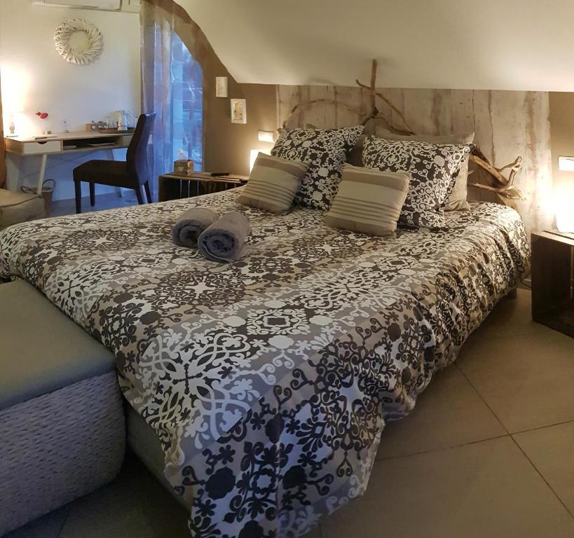a bedroom with a bed with a black and white comforter at La Villa Esterel &amp; SPA in Village-Neuf
