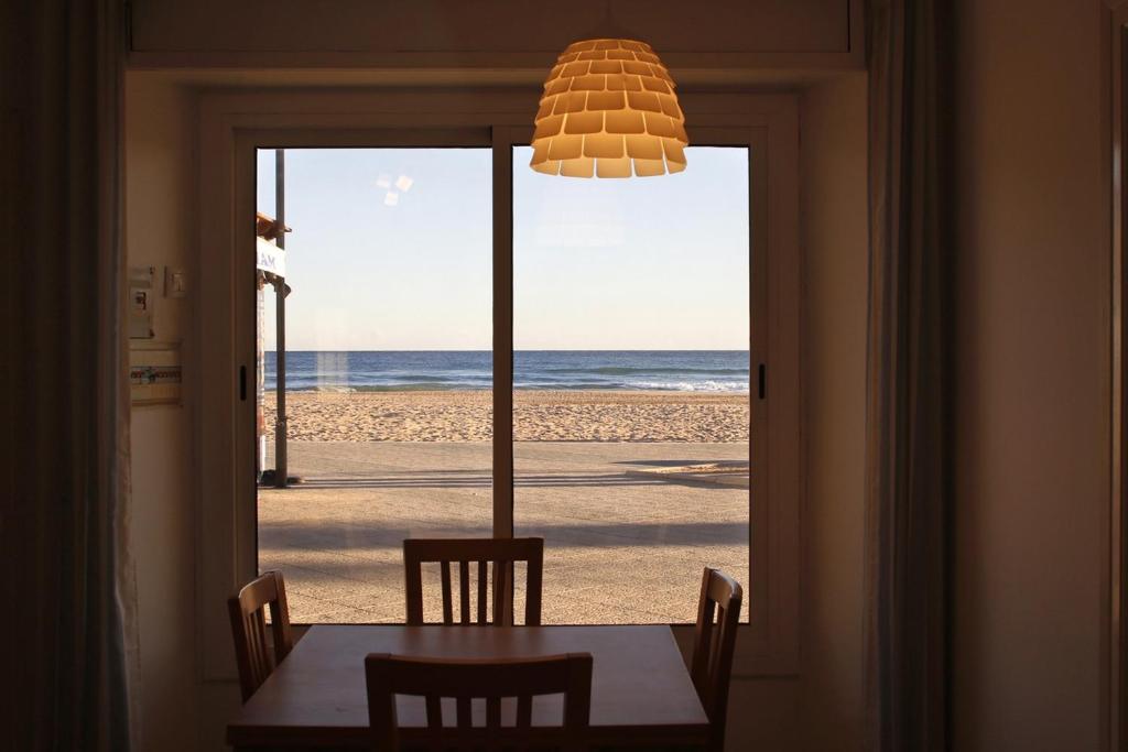 einen Esstisch mit Blick auf den Strand in der Unterkunft AT076 Baix a Mar in Torredembarra