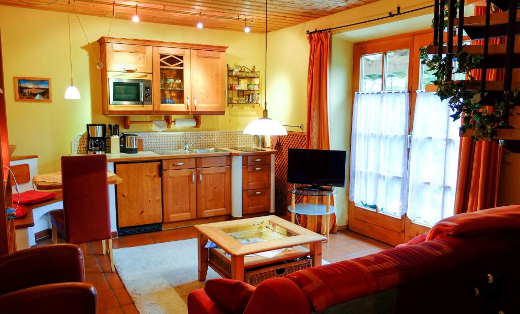 eine Küche mit einem Sofa und einem Tisch in einem Zimmer in der Unterkunft Ferienwohnung Rösslstube in Ruhpolding