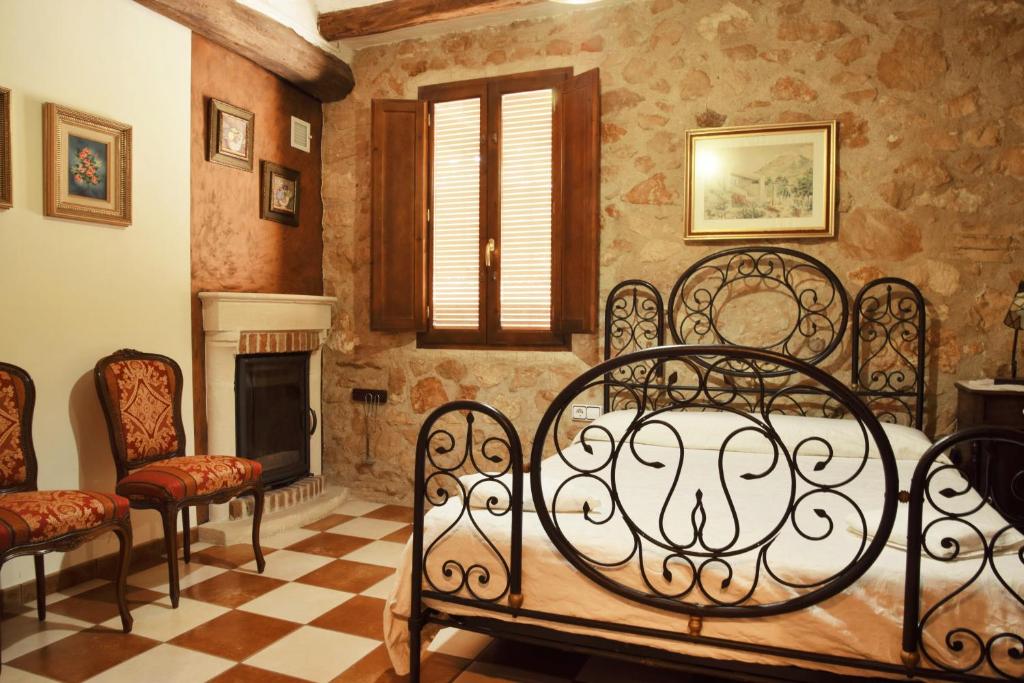 1 dormitorio con 1 cama, 2 sillas y chimenea en Casa Nasiet, en Camporrells