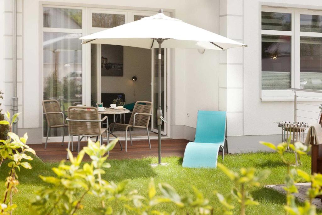 eine Terrasse mit einem Tisch und Stühlen unter einem Sonnenschirm in der Unterkunft Villa Wiederkehr Einkehr in Ostseebad Sellin