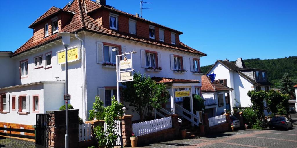 a white house with a brown roof on a street at Hotel Irene in Bad König