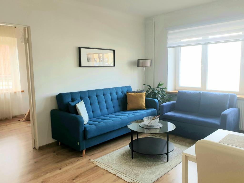 salon z niebieską kanapą i stołem w obiekcie Cozy one bedroom apartment in Old Town w Wilnie