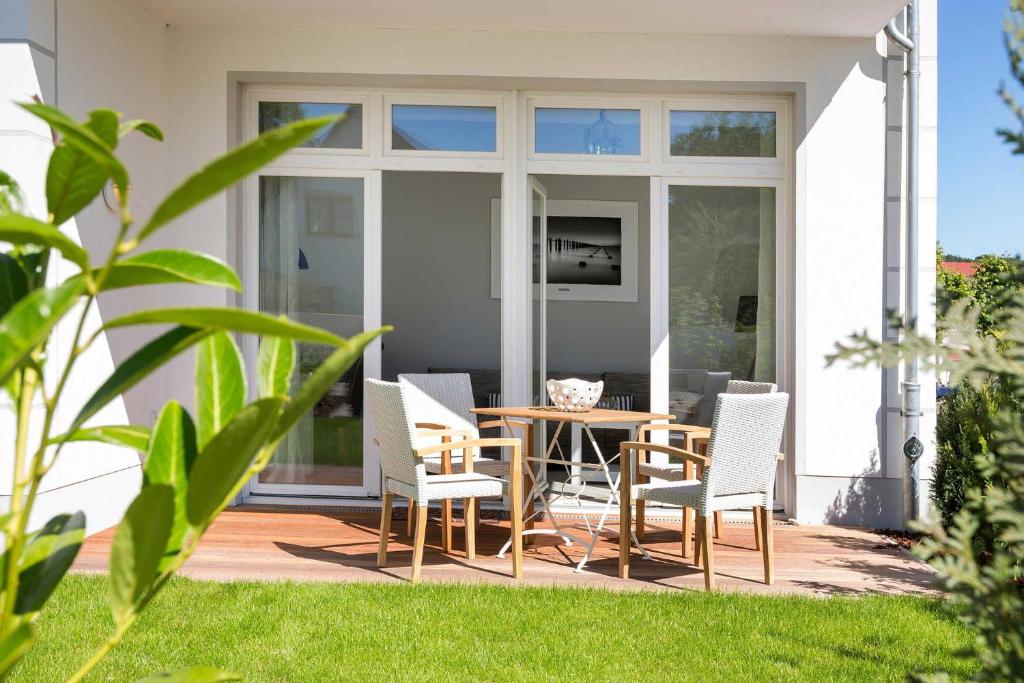 une terrasse avec une table et des chaises dans une maison dans l'établissement Villa Wiederkehr Heimkehr, à Sellin