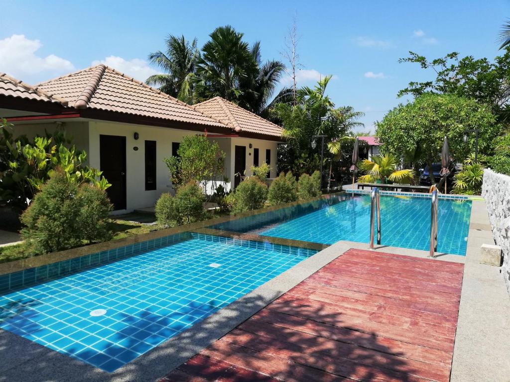 a swimming pool in front of a house at Laemsai Resort in Thalang