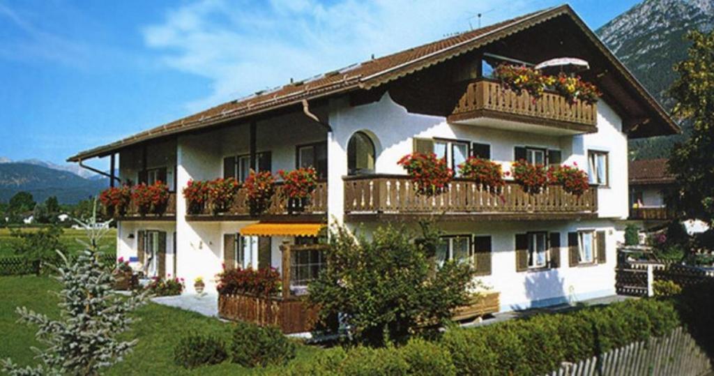 ein großes weißes Gebäude mit Blumenkästen an den Fenstern in der Unterkunft Apartments- und Ferienhaus Anton in Garmisch-Partenkirchen