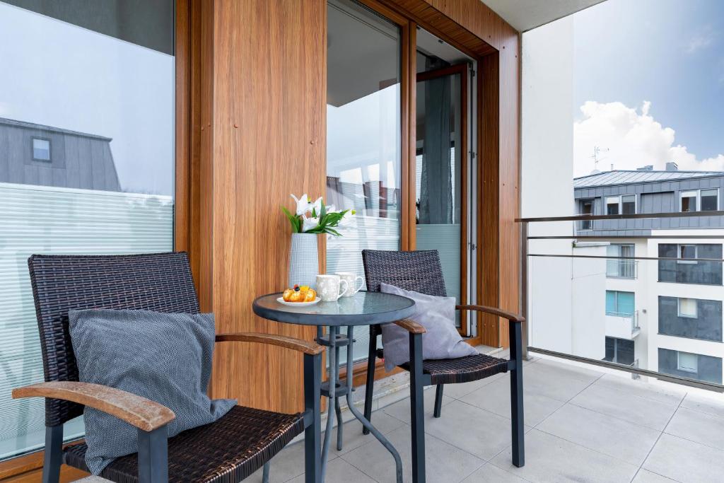 eine Terrasse mit einem Tisch und Stühlen auf dem Balkon in der Unterkunft Apartamenty Pegaz by Renters in Świnoujście