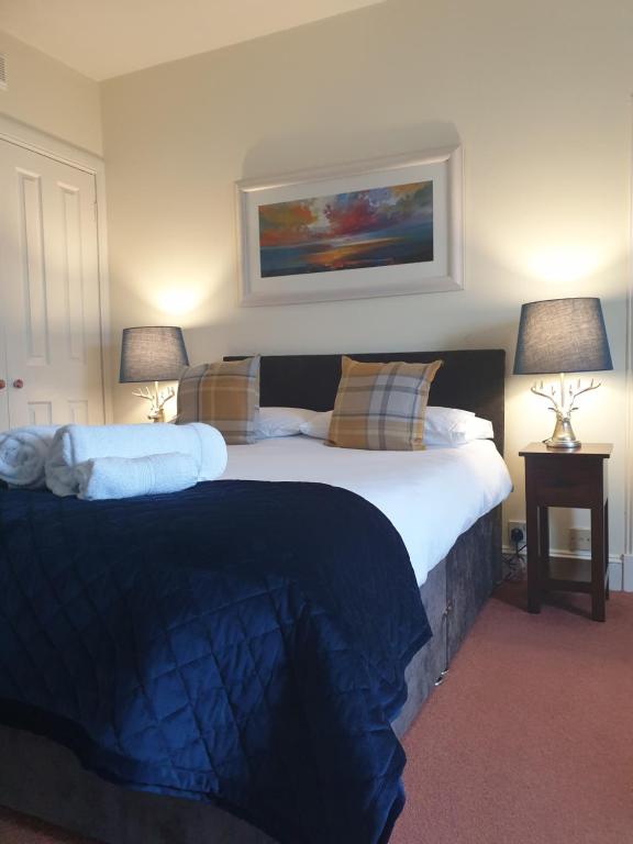 a bedroom with a large bed with two lamps at Rockview in Portree