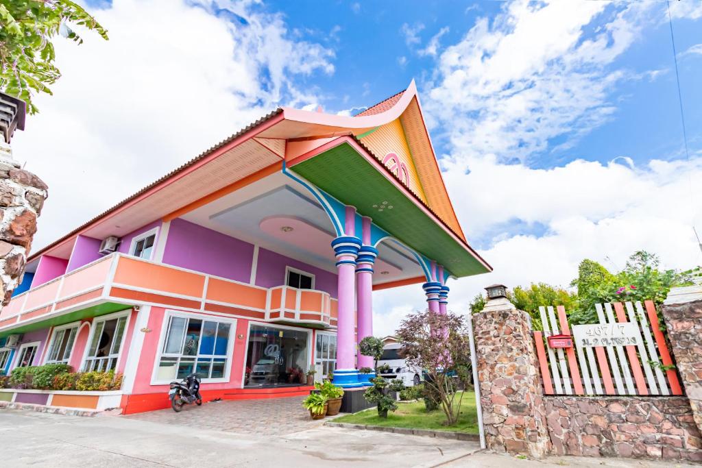 una casa colorata con un grande edificio di M Resort a Songkhla