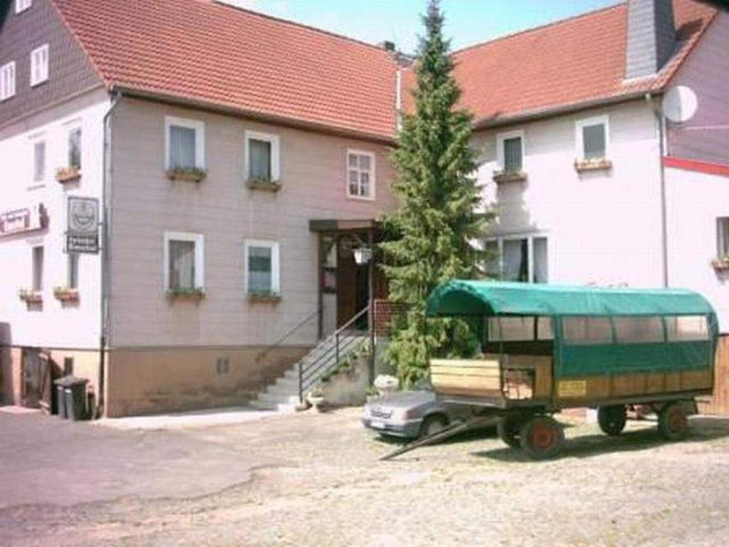 a green trailer parked in front of a building at Reit- und Ferienhof Emstal in Fritzlar