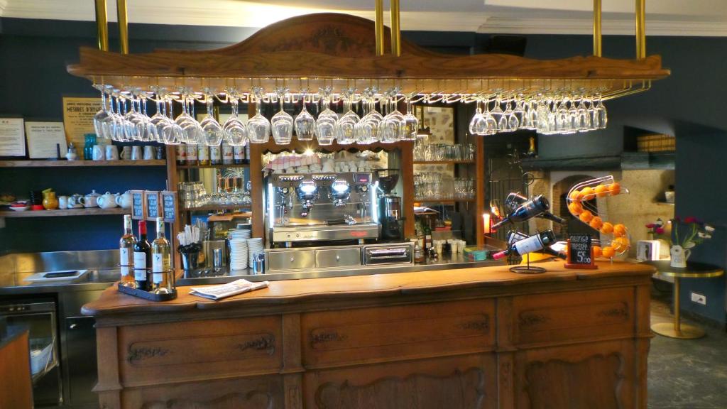 a bar with glasses hanging over the bar at Hotel Relais Du Postillon in Antibes
