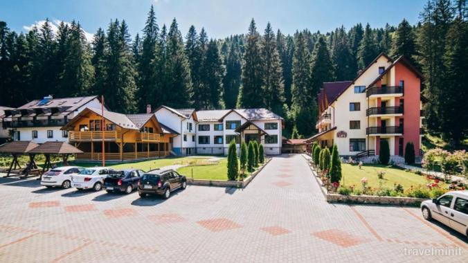 a group of houses and cars parked in a parking lot at Pensiunea Sami in Gura Humorului