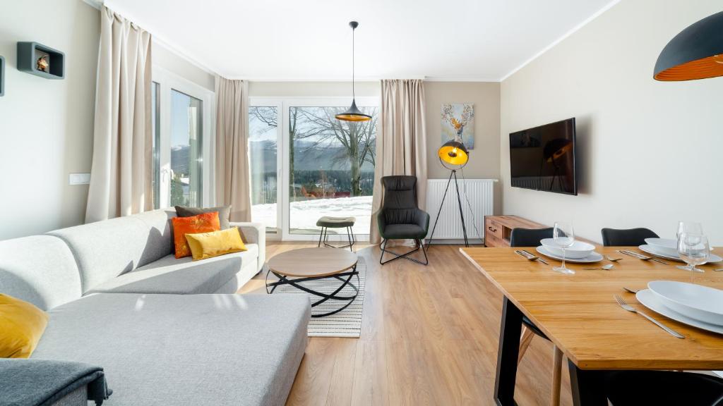 ein Wohnzimmer mit einem Sofa und einem Tisch in der Unterkunft Apartamenty EverySky - Izerska 8 in Szklarska Poręba